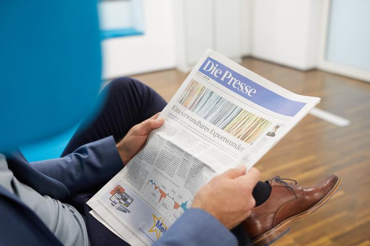 Männliche Person liest entspannt die Titelseite von „Die&nbsp;Presse“